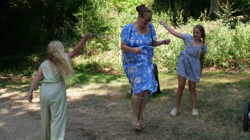 A family playing jump rope in a woodland setting
